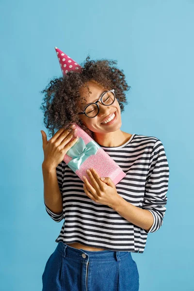 Lycklig kvinna i födelsedagshatt innehav present — Stockfoto