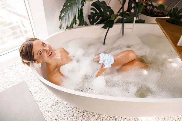 Gyönyörű fiatal nő fürdés örömmel, miközben időt tölt luxus spa üdülőhely — Stock Fotó