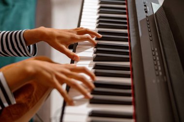 Genç kadın elleri synthesizer klavyesinde çalıyor