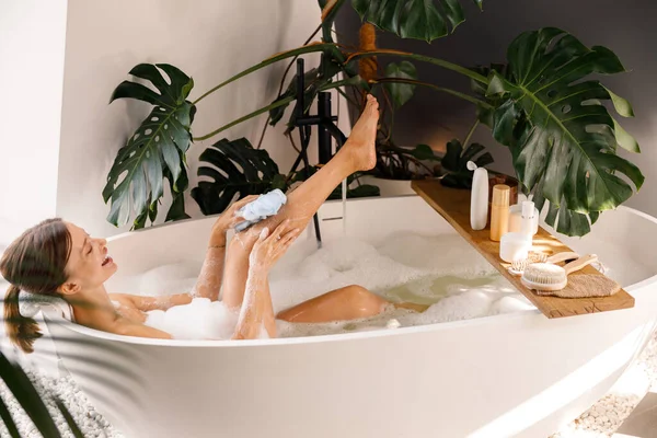 Zijaanzicht van jonge vrouw baden en verzorgen van haar huid in luxe spa resort — Stockfoto