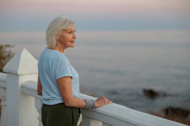 Kafkas kıdemli sporcu kadın deniz kıyısında dinleniyor.