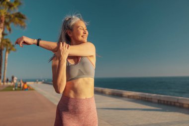 Deniz kıyısında antrenman yapan güçlü bir kadın.