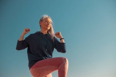 Atletik mutlu kadın limanda aktif olarak antrenman yapıyor.