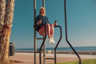 Rıhtımda aktif egzersiz yapan güçlü bir kadın.