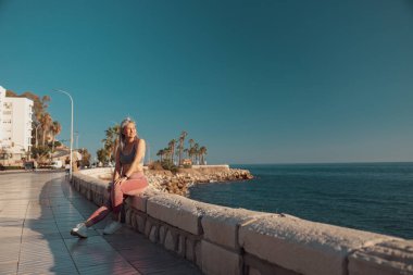 Rıhtımda antrenmandan sonra dinlenen sportif kadın.