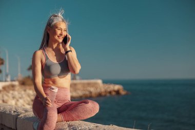 Rıhtımdaki eğitimden sonra gülümseyen kadın dinleniyor.