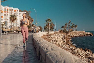 Rıhtımda aktif olarak koşan atletik bayan.