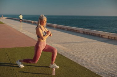 Sahilde sıcak bir günde egzersiz yapan aktif bir dişi.