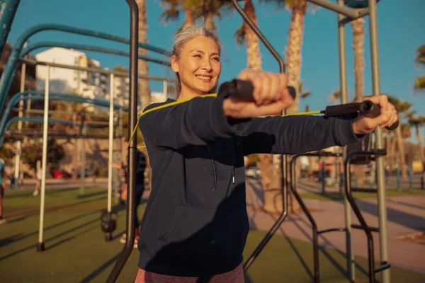 Mujer deportiva haciendo ejercicio al aire libre con bandas elásticas —  Fotos de Stock