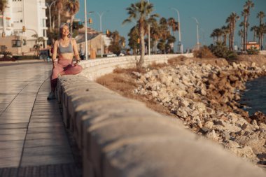 Rıhtımdaki eğitimden sonra dinlenen sportif kadın.