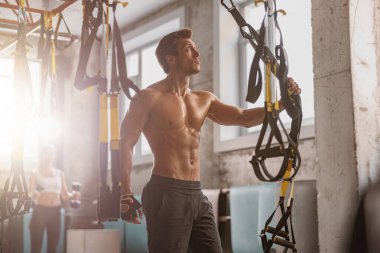 Sporcu adam spor salonunda antrenmana hazırlanıyor.