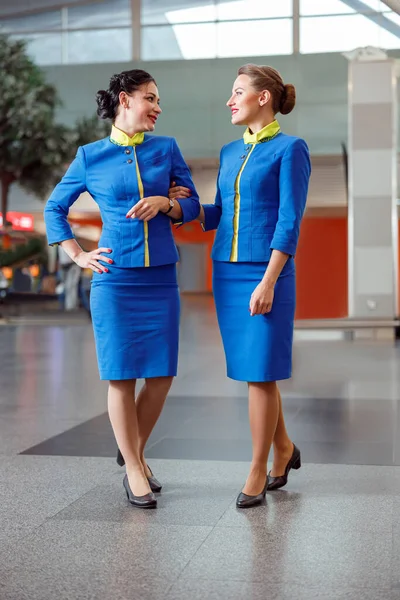 Due hostess allegre che parlano nel terminal dell'aeroporto — Foto Stock