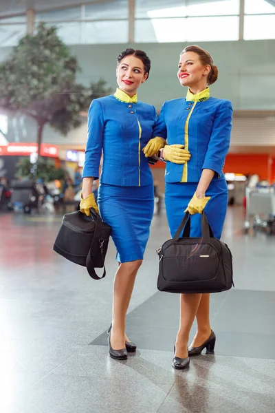 Due hostess a braccetto al terminal dell'aeroporto — Foto Stock