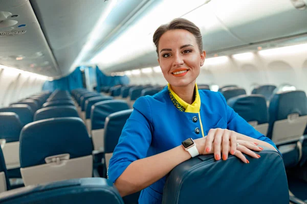 Allegro hostess donna in piedi nel salone passeggeri aereo — Foto Stock