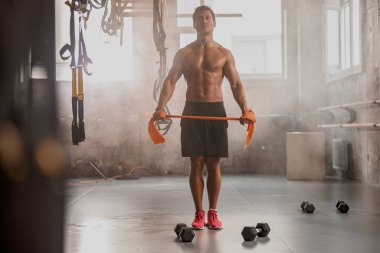 Spor kulübünde egzersiz yapan kaslı genç bir adam.