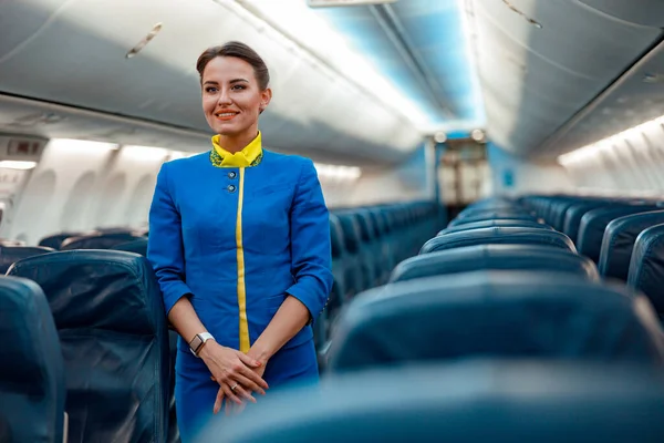 Donna hostess allegra in piedi in cabina passeggeri aerei — Foto Stock