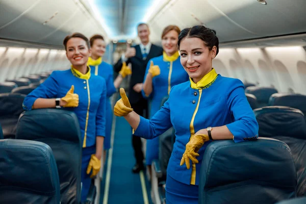 Operai di compagnie aeree che mostrano gesto di approvazione in cabina passeggeri di aerei — Foto Stock
