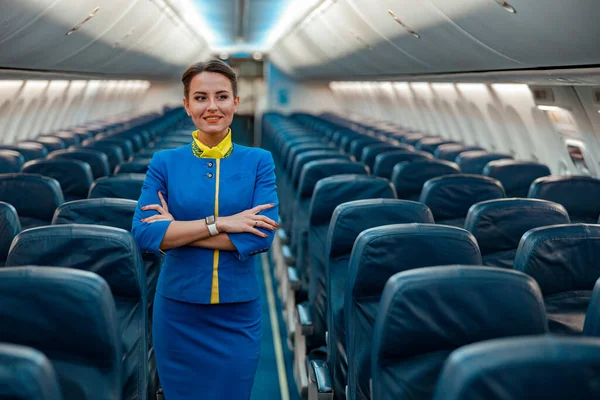 Donna hostess allegra in piedi in cabina passeggeri aerei — Foto Stock