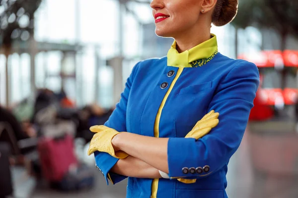 Mulher alegre aeromoça de pé no terminal do aeroporto — Fotografia de Stock