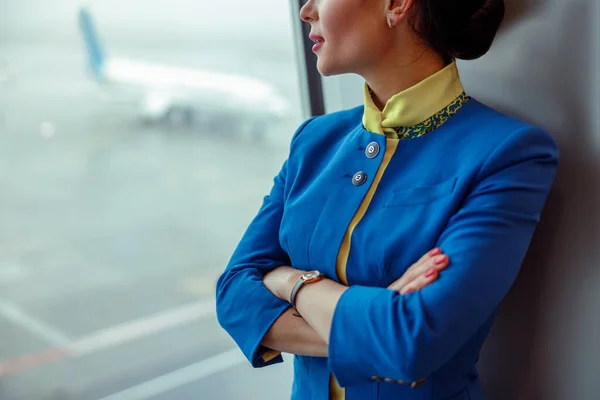 Žena letuška se dívá z okna v letištním terminálu — Stock fotografie