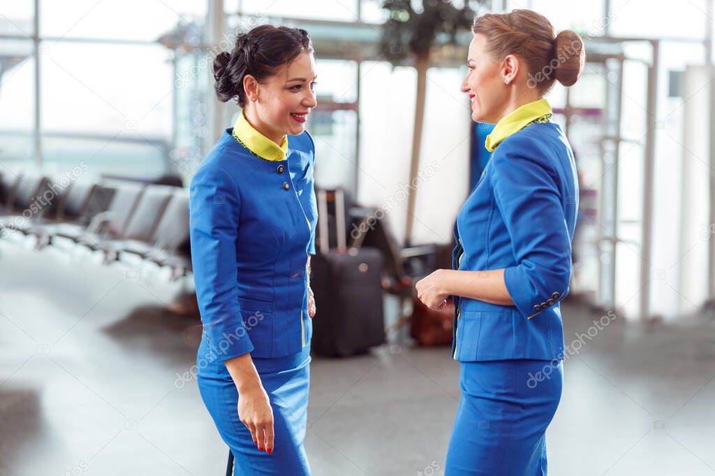 Cheerful flight attendant talking in airport terminal