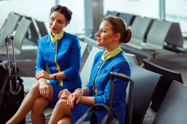 Assistenti di volo donne in attesa del volo in aeroporto — Foto Stock