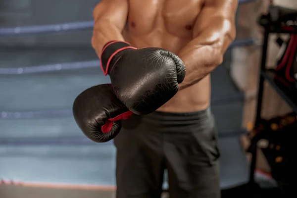 Man in sportbroek met bokshandschoenen naast de boksring — Stockfoto