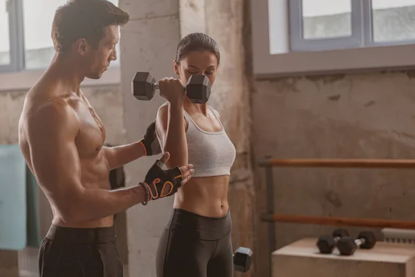 Hombre musculoso en el gimnasio con mujer atlética realizando ejercicios deportivos —  Fotos de Stock