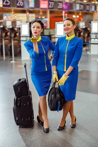 Letušky s cestovními taškami stojící na letišti terminálu — Stock fotografie