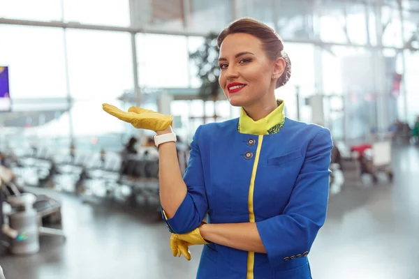 Cheerful woman flight attendant standing in airport terminal — Stock Photo, Image