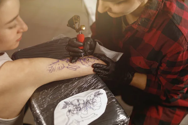 Close-up van tattoo master handen tekening tatoeage op customer arm — Stockfoto