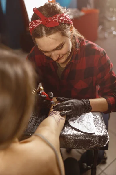 Foto verticale delle mani master del tatuaggio nei guanti che tengono la macchina del tatuaggio — Foto Stock