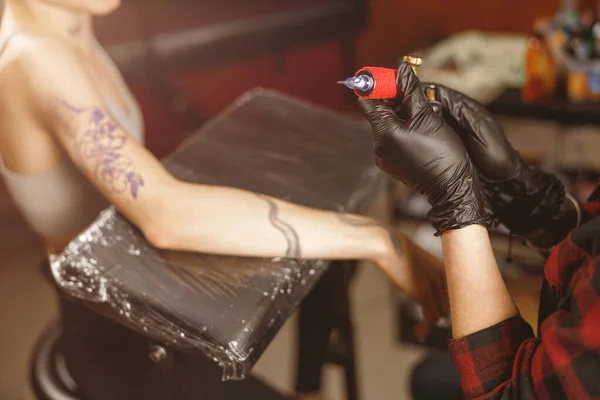 Tatuagem artista segurando máquina de tatuagem no salão — Fotografia de Stock