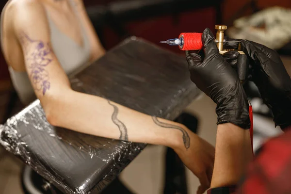 Photo of tattoo master hands in black gloves turning on tattoo machine — Stock Photo, Image