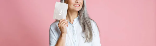 Mooie zilver harige aziatische vrouw houdt gift card met ideeën in studio — Stockfoto