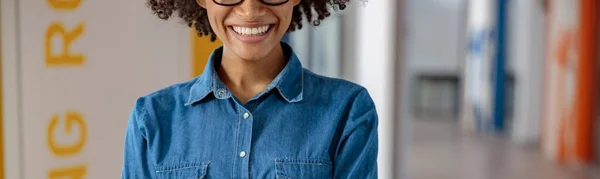 Joyeux jeune femme avec les mains croisées dans le couloir de bureau — Photo