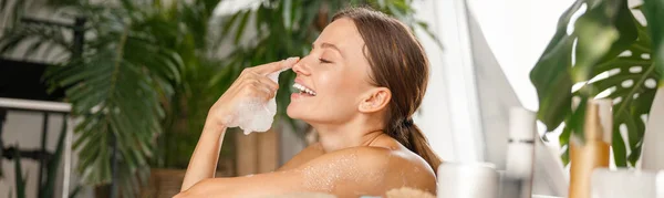 Aranyos fiatal nő szórakozás, játék szappanbuborékok fürdés közben trópusi spa üdülőhely — Stock Fotó