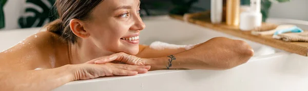 Portré boldog fiatal nő mosolyog félre, miközben pihen fürdőkádban luxus spa üdülőhely — Stock Fotó