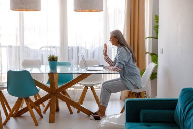 Evde internet bağlantısı için dizüstü bilgisayar kullanan bir kadın