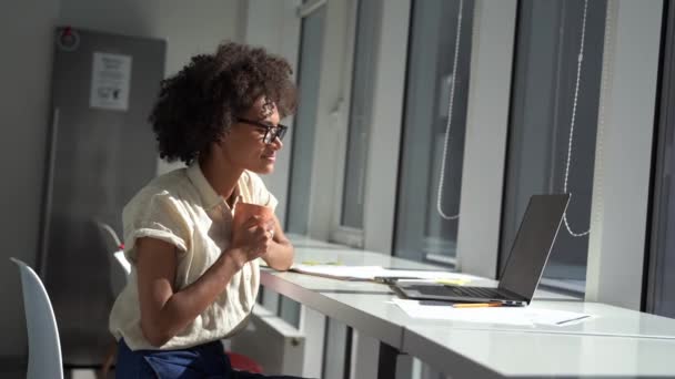 Jonge zakenvrouw in modern licht minimalistisch kantoor is met behulp van laptop voor werk en communicatie — Stockvideo