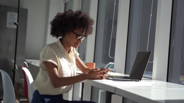 Mujer de negocios joven en la oficina minimalista luz moderna está utilizando el teléfono inteligente para las comunicaciones — Vídeo de stock