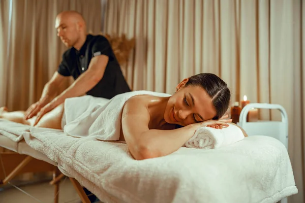 Kvinna som ligger med slutna ögon, njuter av professionell massage på spa-centret — Stockfoto
