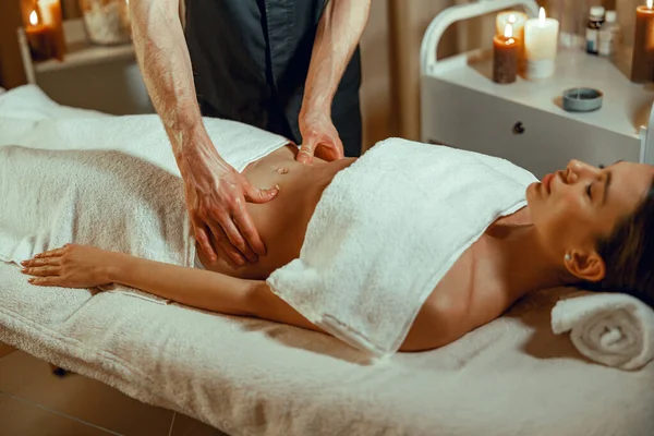 Relaxált női ügyfél kap gyomormasszázs spa szalonban — Stock Fotó