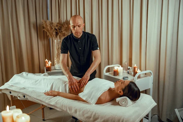 Alternativ medicin manlig terapeut gör massage till kvinnlig klient liggande på en dagbädd — Stockfoto