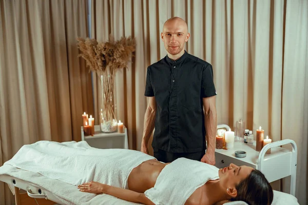 Professionell manlig massör gör massage till kvinnliga klienten i spa salong. Slappna av — Stockfoto