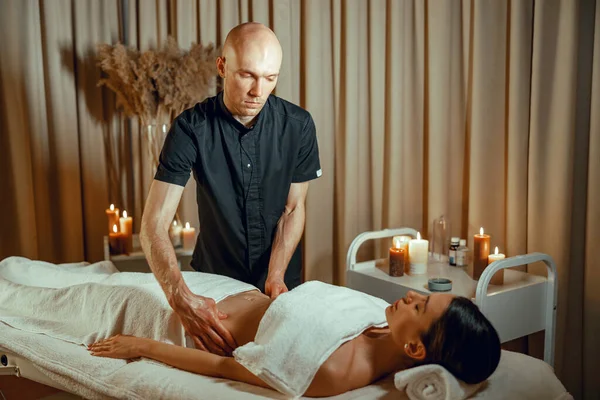Alternativní medicína lázeňský salon terapeut dělá masáž pro ženy ležící na denním lůžku — Stock fotografie