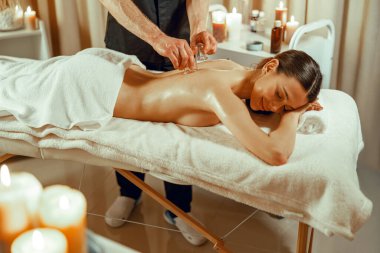 Rahat bayan müşteri özel bardaklarla elektrikli süpürge masajı yaptırıyor. Çin masajı