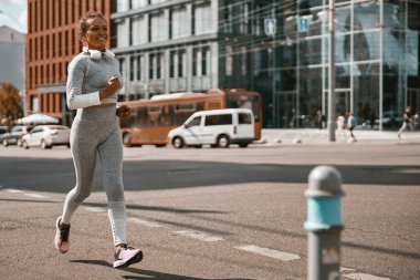 Kadın koşucu, salgın sırasında güneşli bir günde dışarıda düzenli olarak antrenman yapıyor.