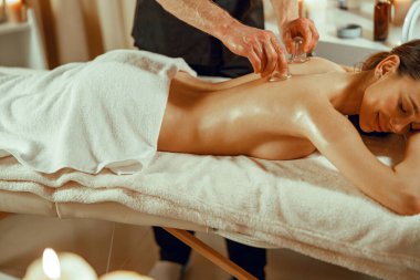 Profesyonel erkek terapist özel fincanlarla vakum masajı yapıyor. Çin masajı