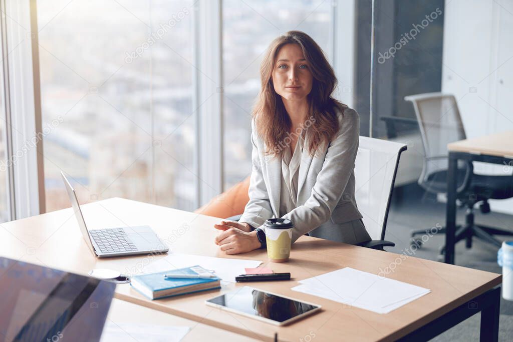 Portrait of smiling beautiful business woman working in office use computer with copy space.